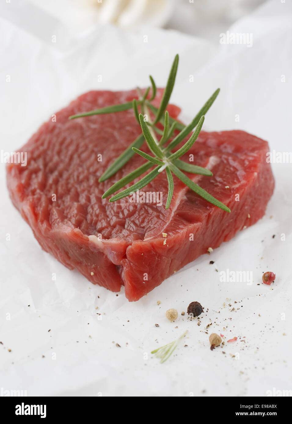 Portion gesunden mageres Steak, garniert mit frischem Rosmarin als Gewürz warten darauf, für eine nahrhafte Mahlzeit gekocht werden Stockfoto