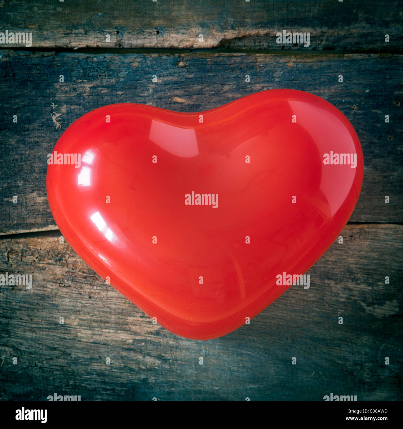 Roten romantische Valentinstag oder Weihnachten Herz für den Versand besondere festliche Grüße an ein Schatz oder geliebten auf einen strukturierten Hintergrund aus Holz Stockfoto