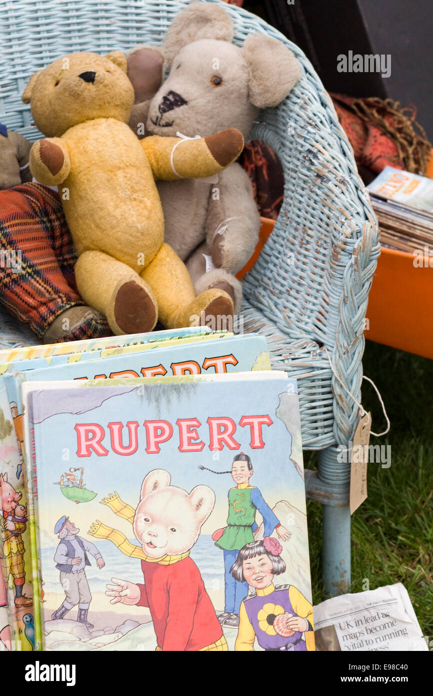 Vintage Retro Stall mit Rupert Bär Jahrbücher und Stofftiere in einem Korbstuhl Stockfoto