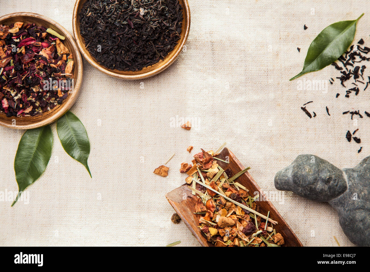 Nahaufnahme von Arznei-und Gewürzpflanzen, Blätter und eine asiatische antike Statue, Symbol der traditionellen chinesischen Medizin Stockfoto