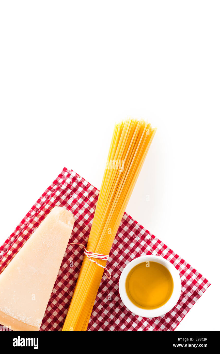 Keil aus italienischer Käse mit einem Bündel von ungekochten Spaghetti und kleine Schüssel mit Olivenöl auf einem frischen roten und weißen aufgegebenes Tuch bereit, eine gesunde vegetarische Mahlzeit zubereiten Stockfoto