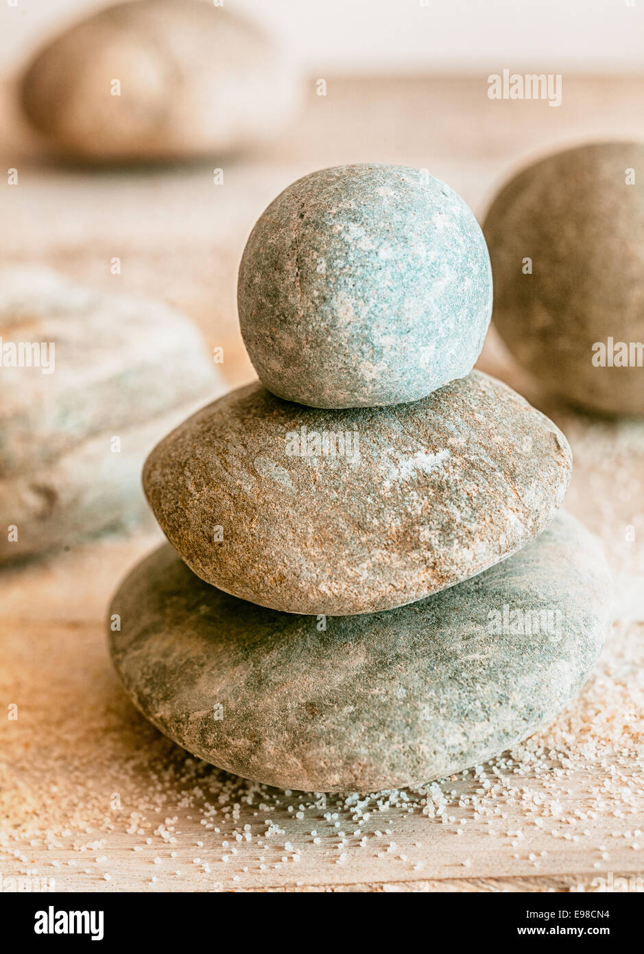 Gestapelte natürlichen gerundet verwitterte Zen Steinen mit verstreuten Strandsand konzeptionelle von Spa, Wellness, Spiritualität und meditation Stockfoto