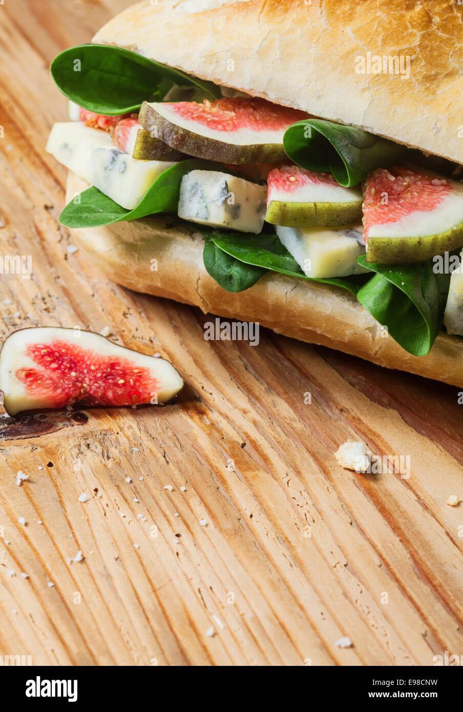 Herzhaft frisch gebacken Roll gefüllt mit gewürfelten Feigen, Blattspinat und salzig Blauschimmelkäse für einen leckeren gesunden Mittagsimbiss Stockfoto