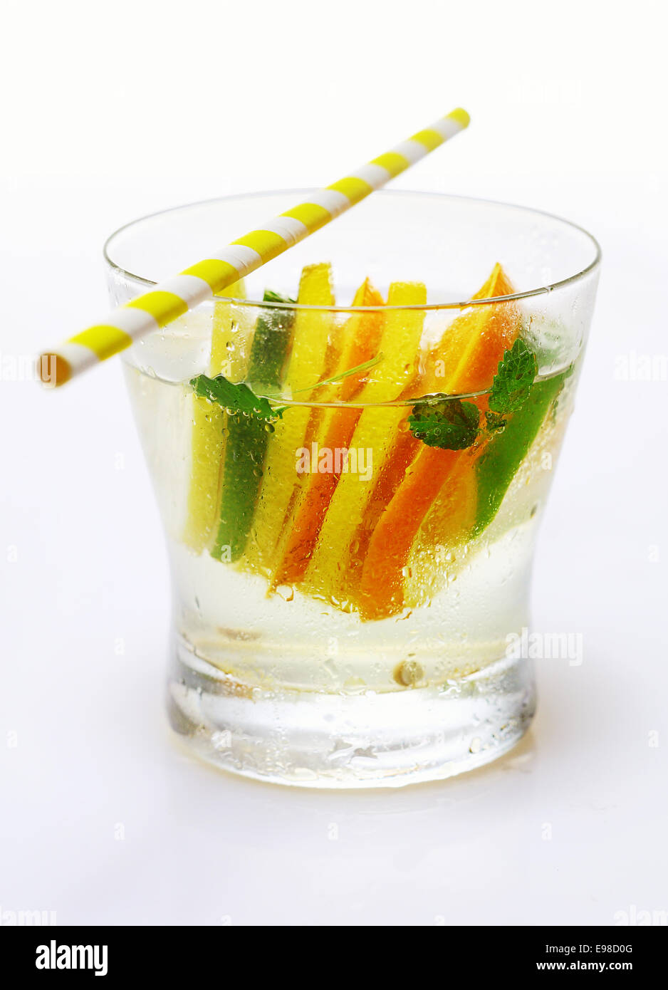 Tropische Zitrusfrüchte-Cocktail mit Wodka, garniert mit abwechselnden Scheiben Zitrone und Orange mit einem Strohhalm serviert Stockfoto