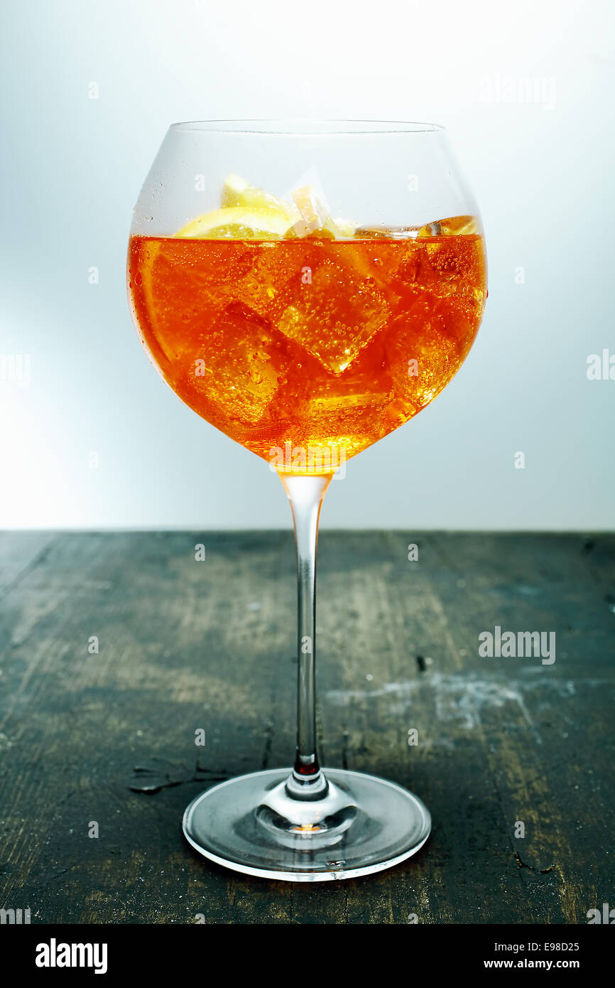 Gekühlte tropischen Aperol, Rum und Orange cocktail in einem eleganten Glas Wein auf einer hölzernen Theke in einer Bar oder einem club Stockfoto