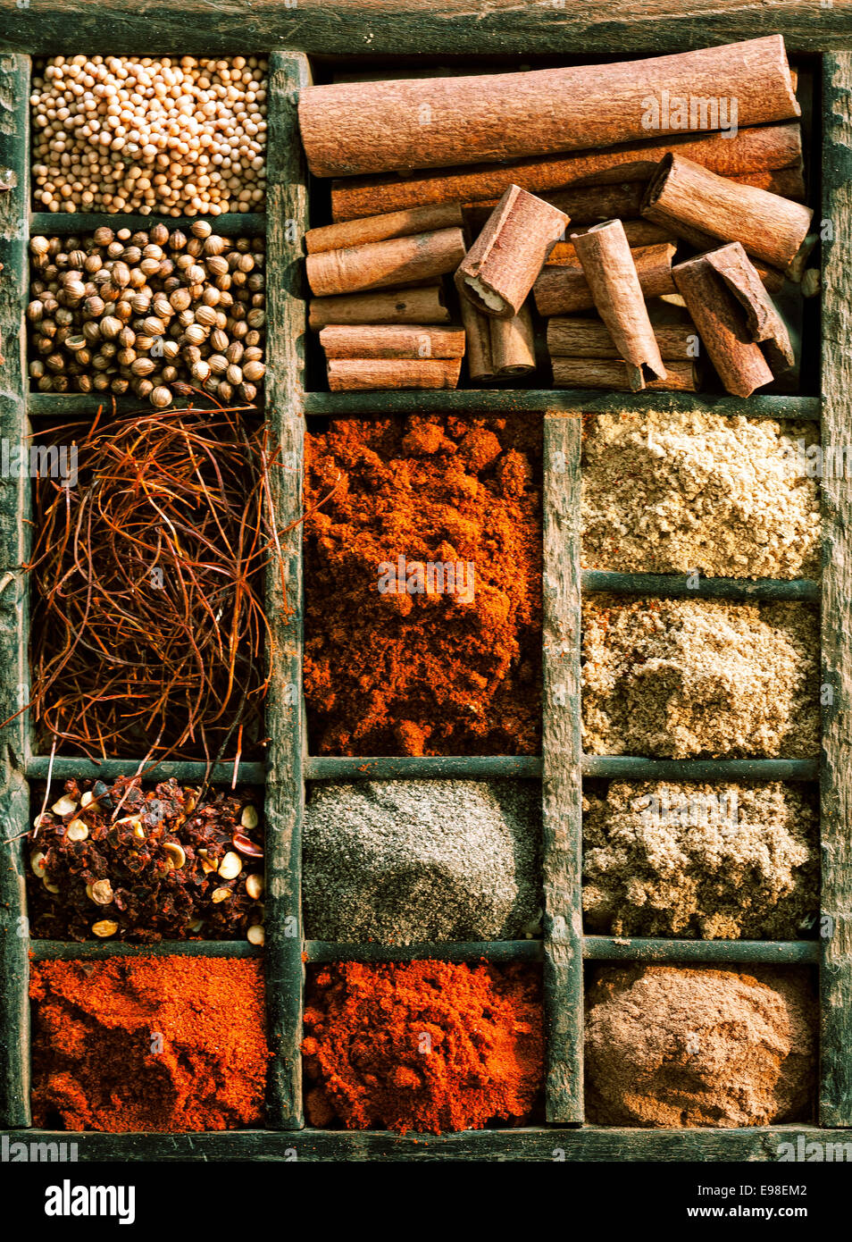 Verschiedene Arten von Gewürzen, Knoblauchpulver und Zimt, Paprika in einer Holzkiste, hoher Winkel Stockfoto