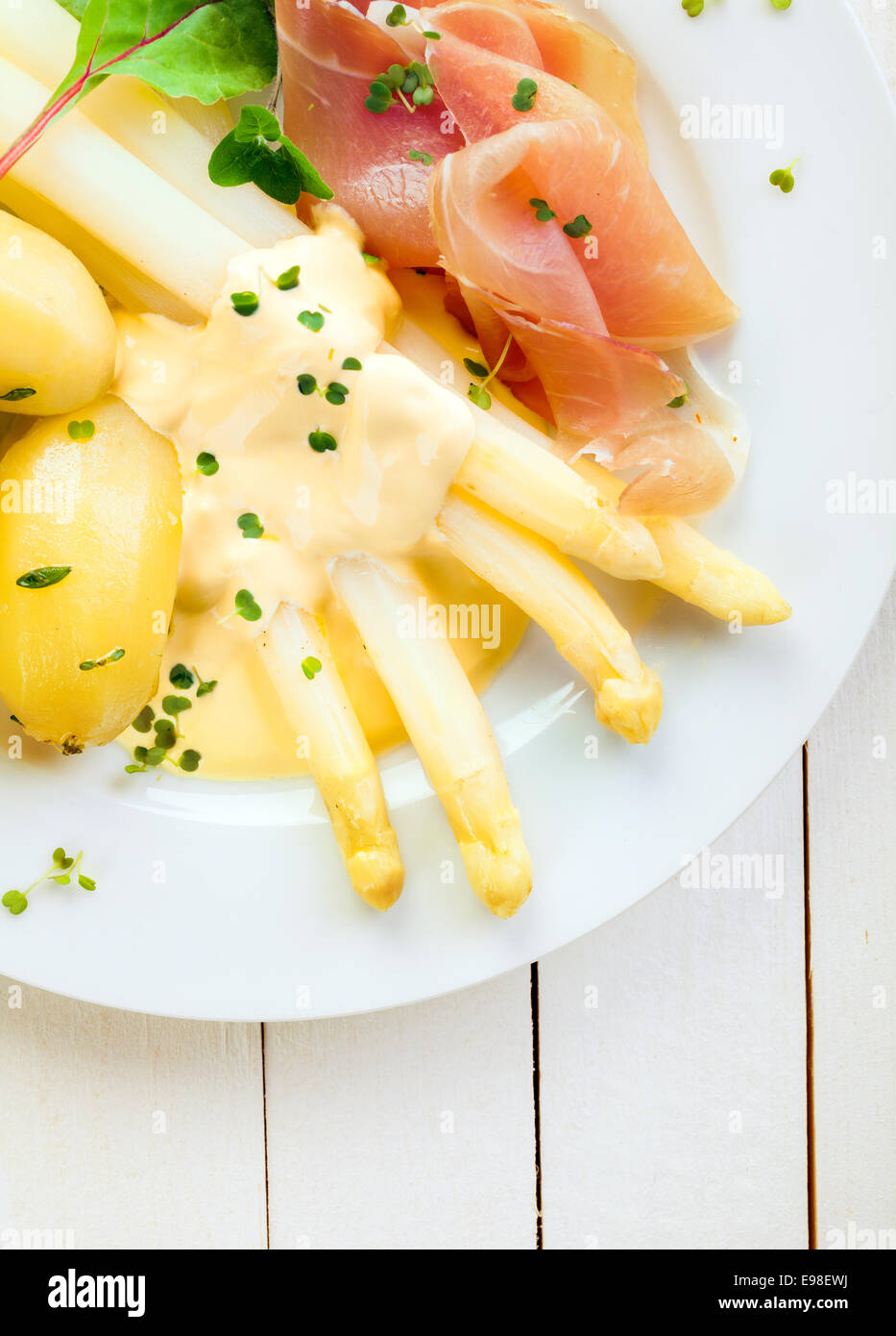 Köstliches kaltes Abendessen von Spargel und Schinken Schinken serviert mit Mayonnaise und Baby Salzkartoffeln garniert mit frischen gehackten Kräutern, Draufsicht auf einem weißen Teller und Tisch hautnah Stockfoto