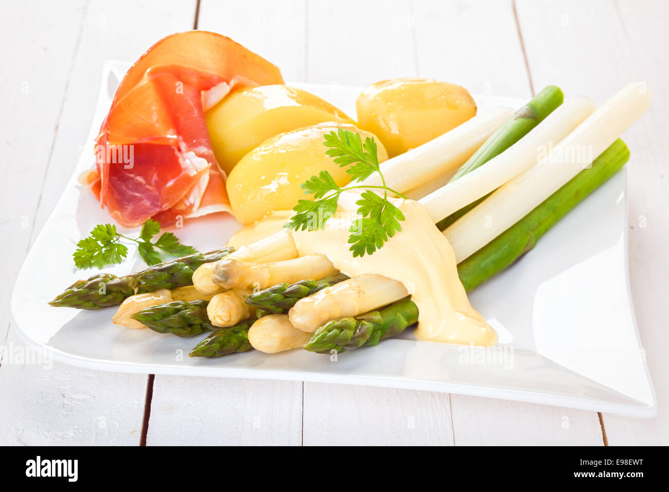 Gekocht kalt weißen und grünen Spargel mit Schinken und gekochte Kartoffeln mit Mayonnaise und frischem Koriander auf einem modernen weißen Teller serviert Baby, Nahaufnahme Stockfoto