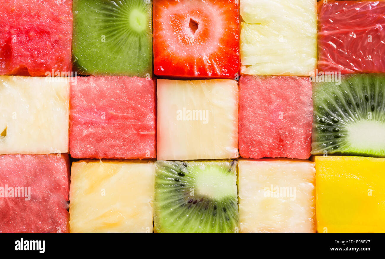 Hintergrundtextur gewürfelte tropischen Sommer Früchte in Würfel schneiden und in Reihen angeordnet, für ein nahtloses Muster mit Wassermelone, Erdbeeren, Kiwis, Ananas und Melone Stockfoto