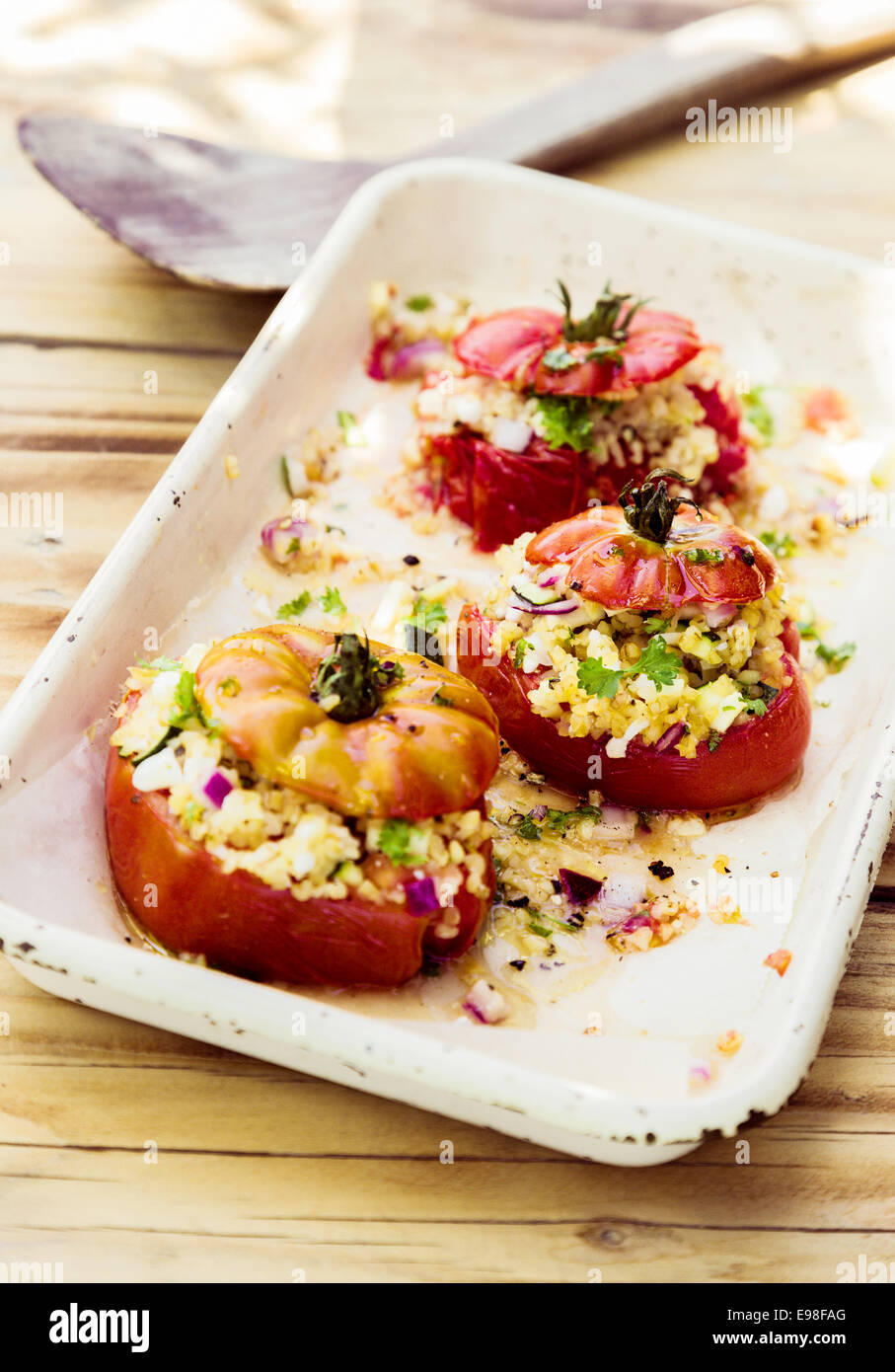 Leckere gesunder vegetarische Küche mit Reife rote Tomaten gefüllt mit Vollkorn, Zwiebeln und Kräutern und Ofen geröstet Stockfoto