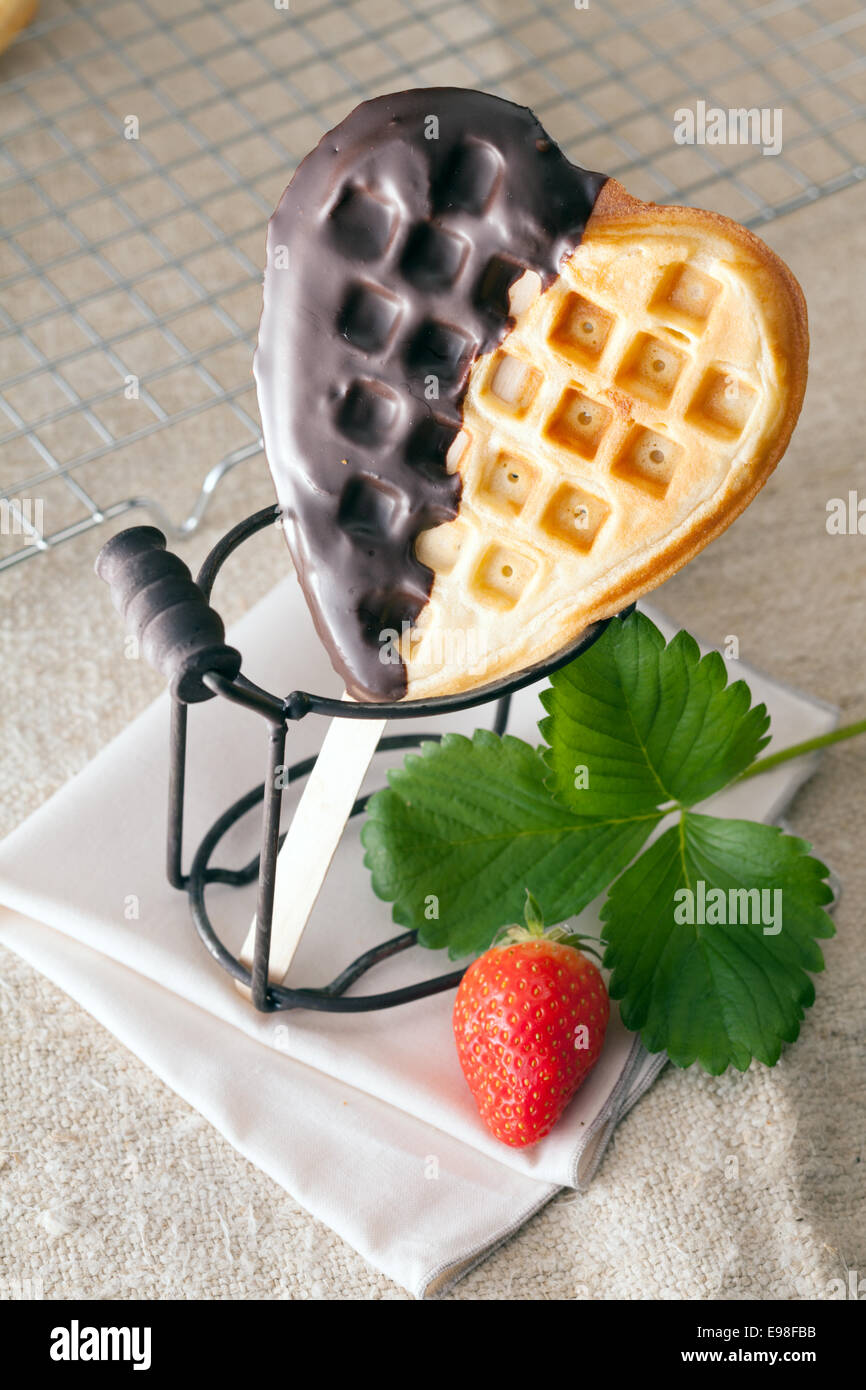 Knackig knusprigen goldenen herzförmige Waffel auf einer Seite mit Schokolade überzogen