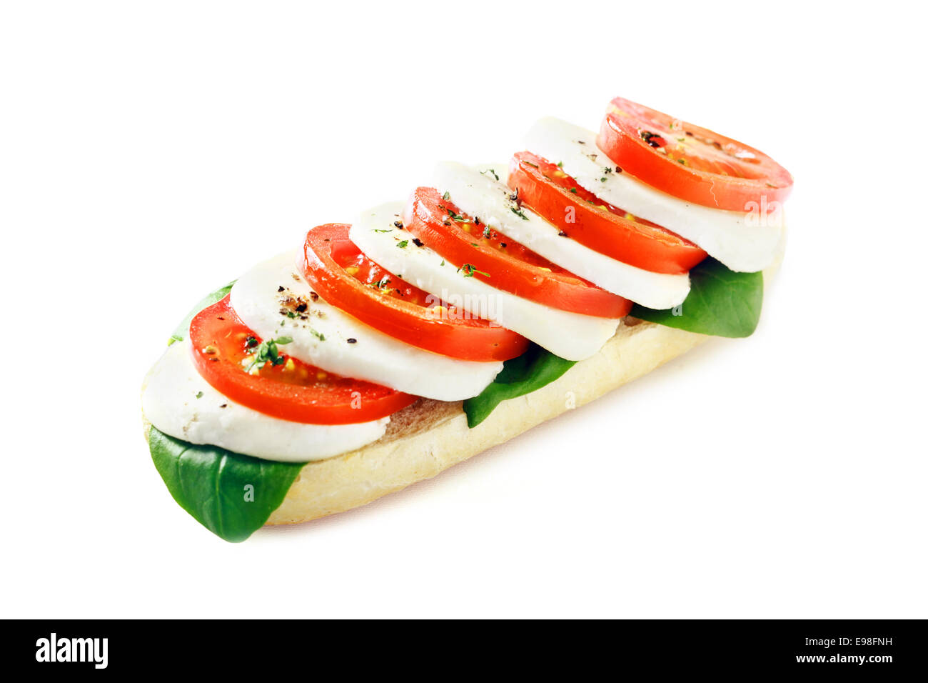 Abwechselnd cremigem Mozzarellakäse und Reife rote Tomate mit Kräutern auf eine Open-Sandwich auf weißem Hintergrund Stockfoto