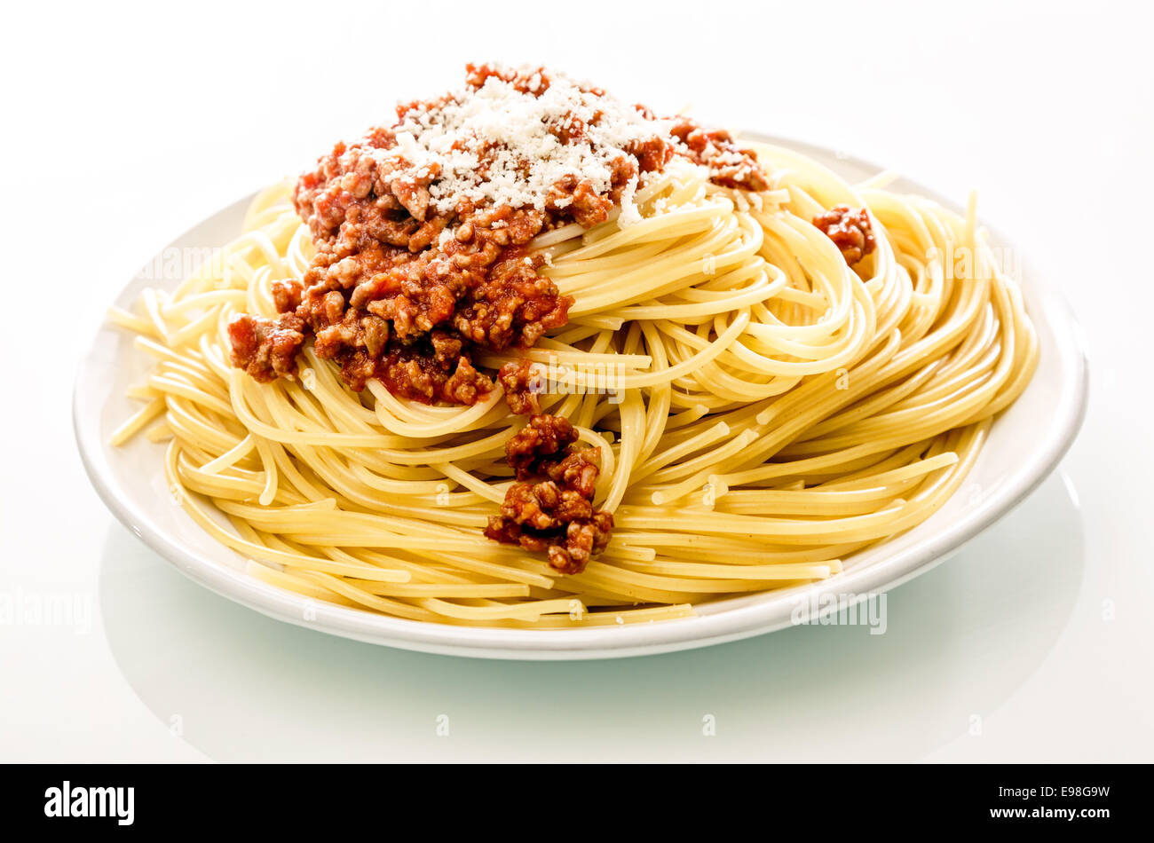 Platte italienische Spaghetti Nudeln mit herzhaften Rindfleisch Hackfleisch und geriebenem Parmesan auf weißem Hintergrund Stockfoto