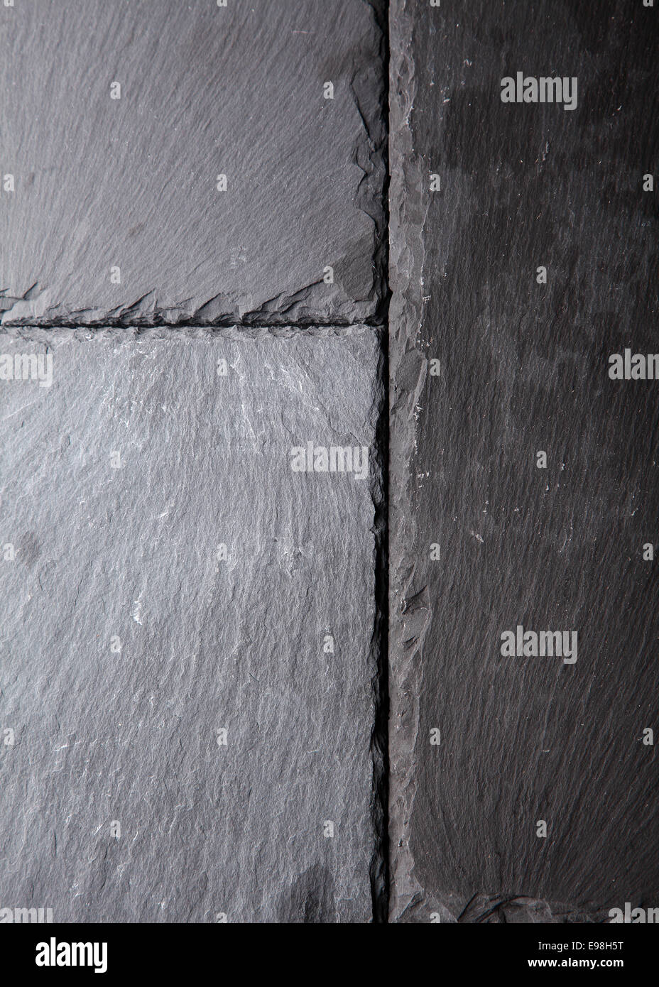 Strukturierten Hintergrundmuster der natürlichen dunklen grauen Schiefer Fliesen anschlagenden einander mit rauen Oberflächen und leicht angeschlagenen Kanten Stockfoto