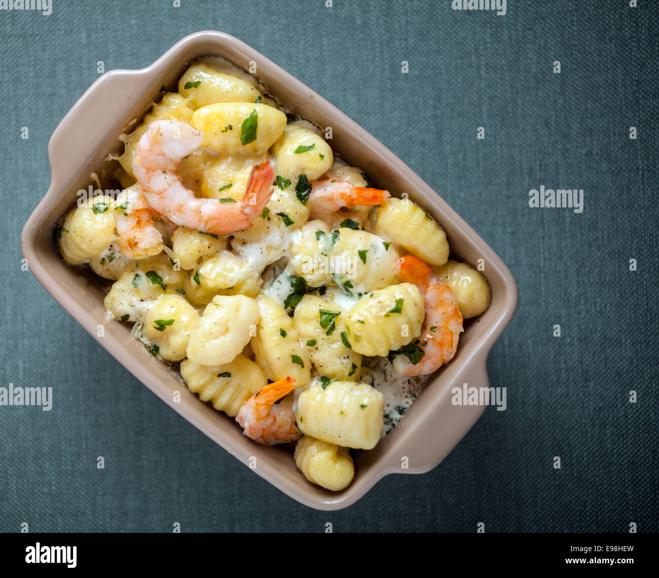 Leckere gegrillte geschälte Garnelen in italienische Gnocchi-Nudeln mit frischen Kräutern gewürzt Draufsicht auf eine Kasserolle Stockfoto