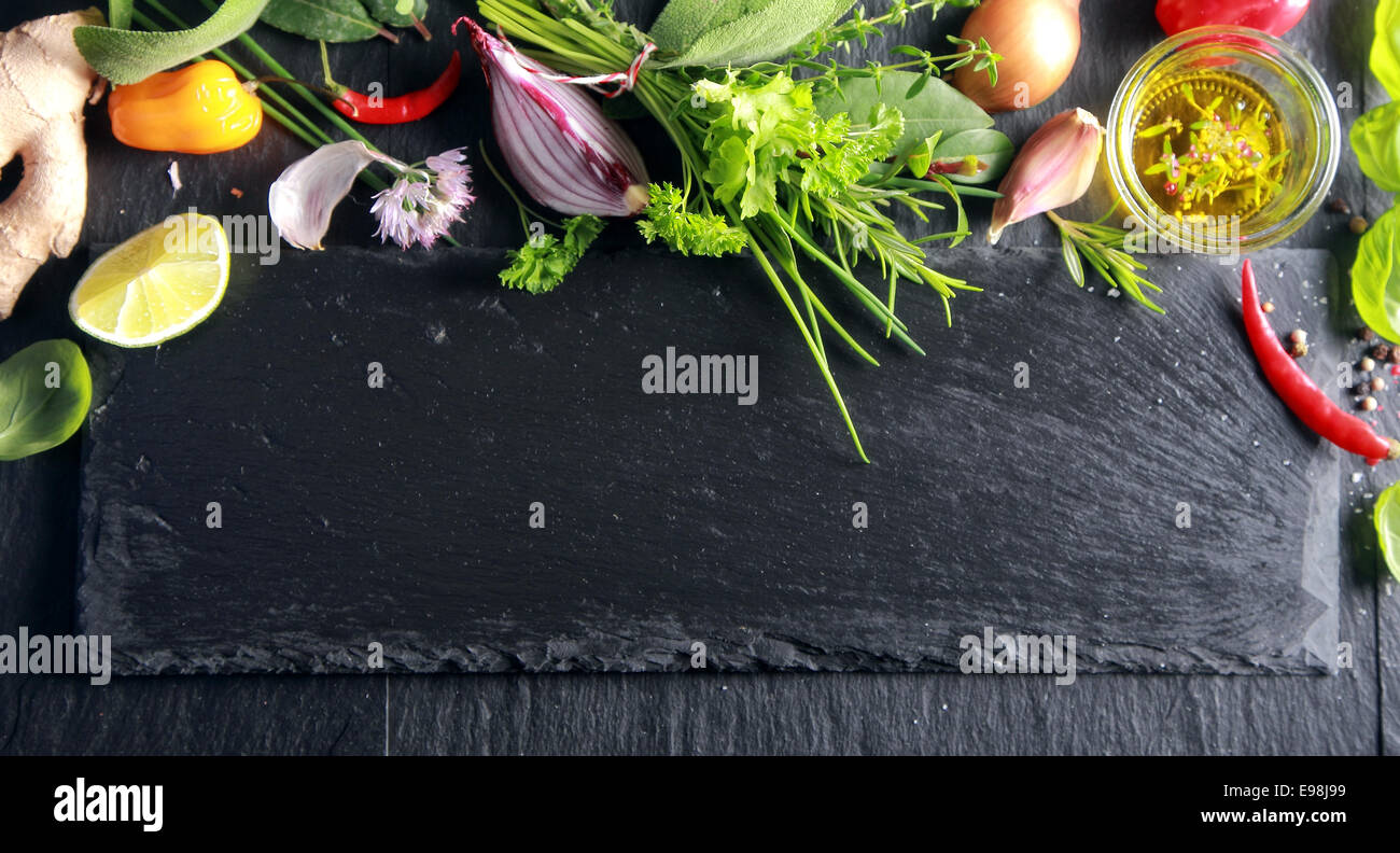 Obere Grenze von frischem Obst, Gemüse, gewürzten Olivenöl und Kräutern auf eine strukturierte Schiefer dunkel mit Exemplar Stockfoto
