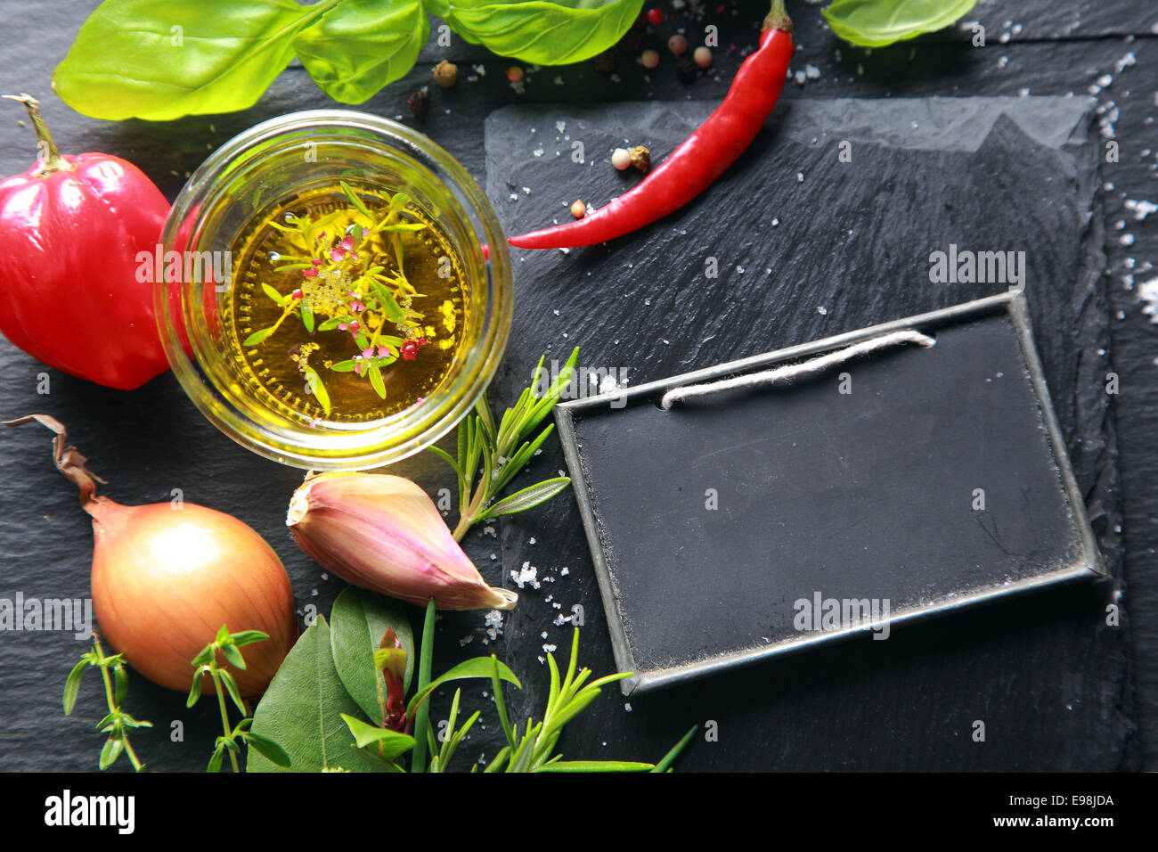 Frische Kräuter, Zwiebel, Knoblauch, Paprika und gewürzten Olivenöl für den Einsatz als aromatische Würze und Zutaten in der Küche mit einem Stockfoto