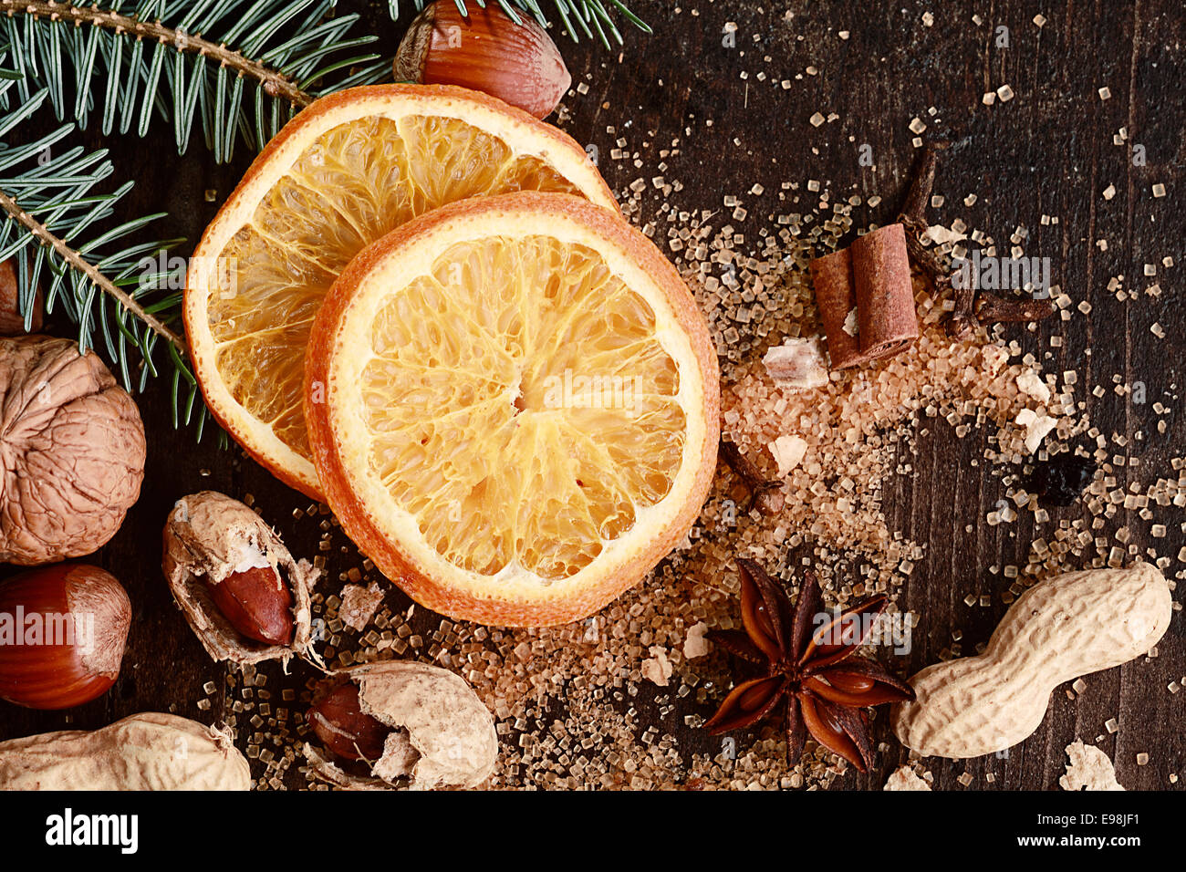 Gesüßte Weihnachten Orange, Muttern auf Seite auf braunen Holztisch. Stockfoto