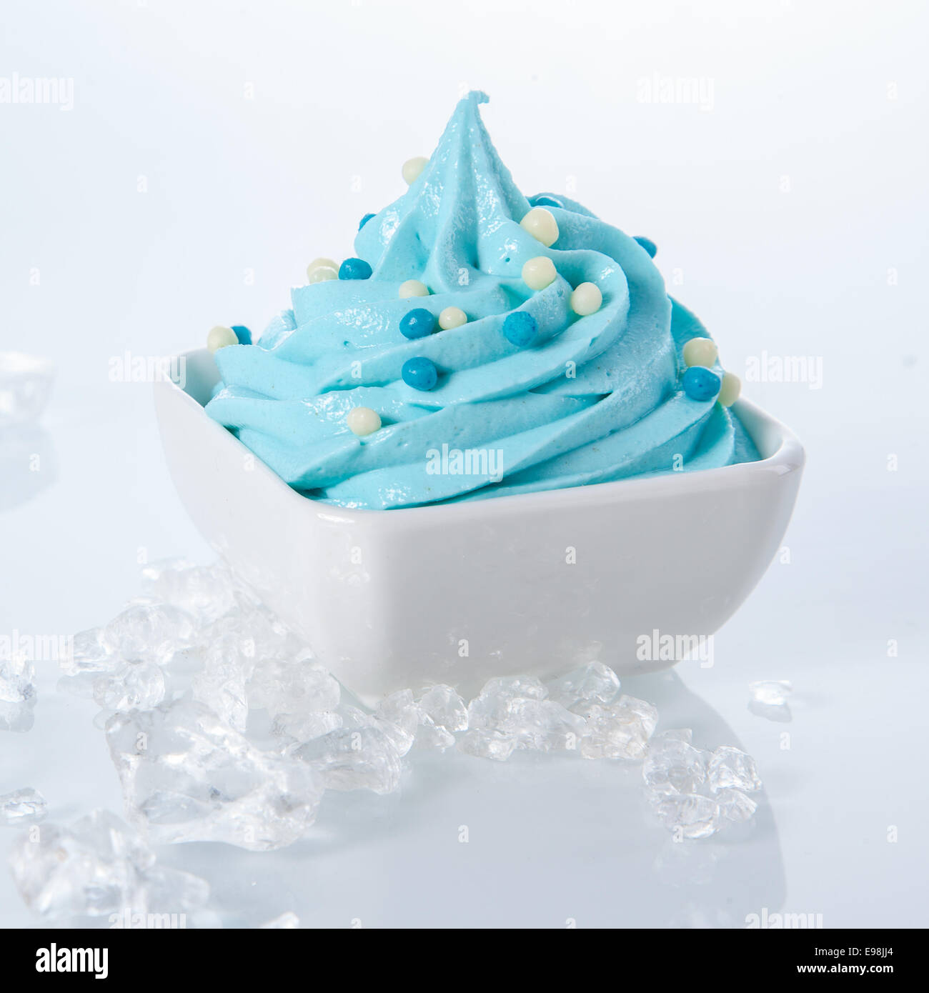 Schließen Sie gefroren leckeren Joghurt auf Schale umgeben von Eis isoliert auf weißem Hintergrund. Stockfoto