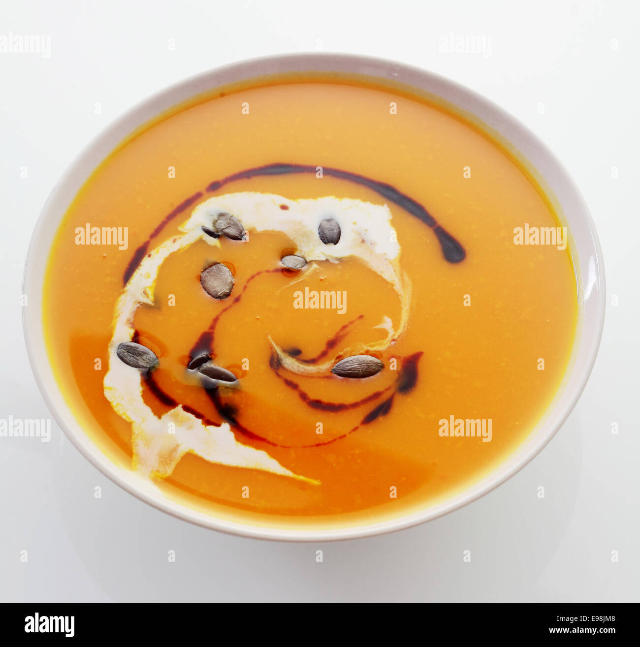 Nahaufnahme von oben eine Schüssel cremig Kürbis oder Butternut Suppe, dekoriert mit einem Wirbel von Creme und Soja-Sauce für eine leckere vegetarische Vorspeise Stockfoto