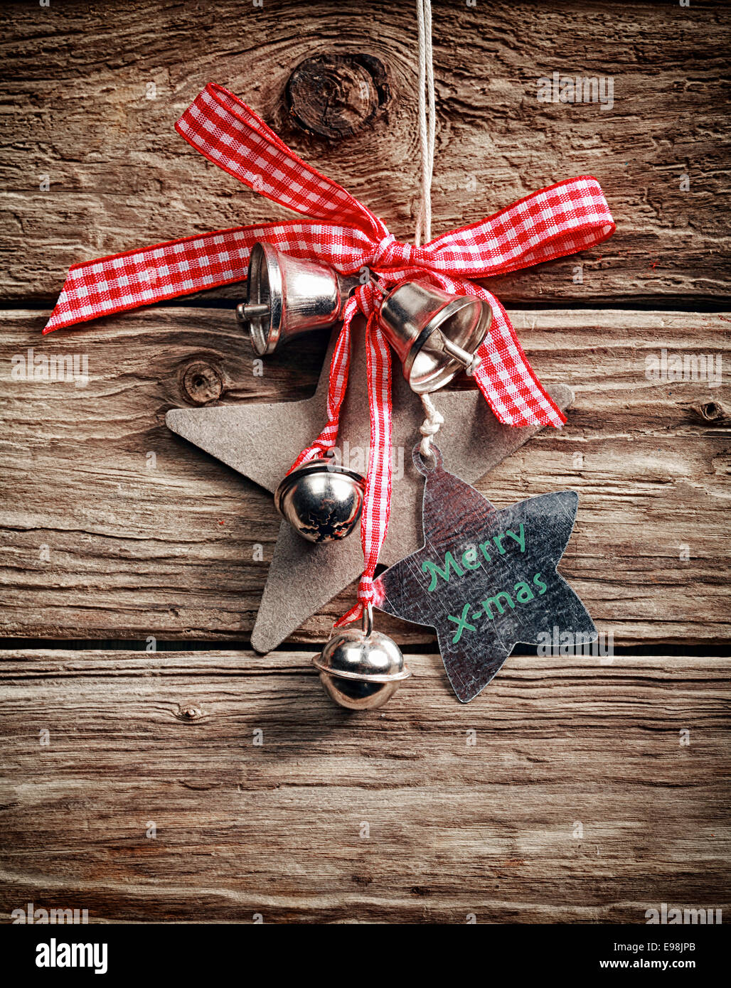 Traditionelle Weihnachts-Dekoration mit karierten Schleife, Silber Glocken und Sternformen wünschen Frohe Weihnachten, eine rustikale Holzwand hängen Stockfoto