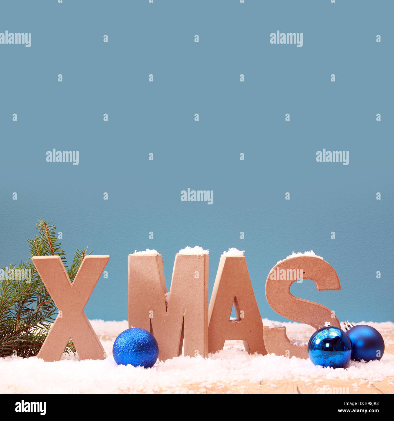 Cool blue Xmas Hintergrund mit Schnee und bunte Christbaumkugeln in einem winterlichen saisonalen Thema mit Exemplar für Ihre Begrüßung, Stockfoto