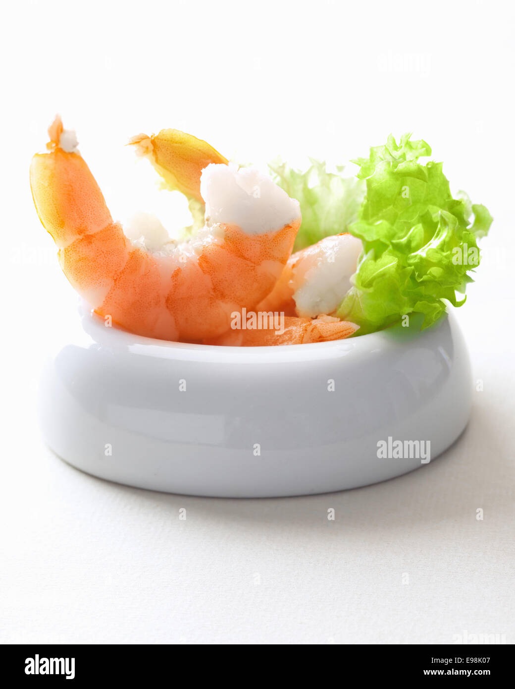 Scampis in einer Schüssel mit Salat auf weiß Stockfoto