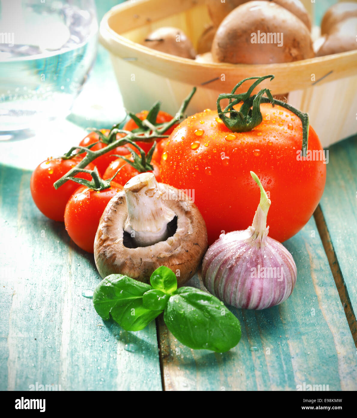 Frisch kochen Zutaten für Pasta mit Pilzen, Knoblauch, Tomaten und frischen Kräutern auf urigen Holzbrettern. Stockfoto