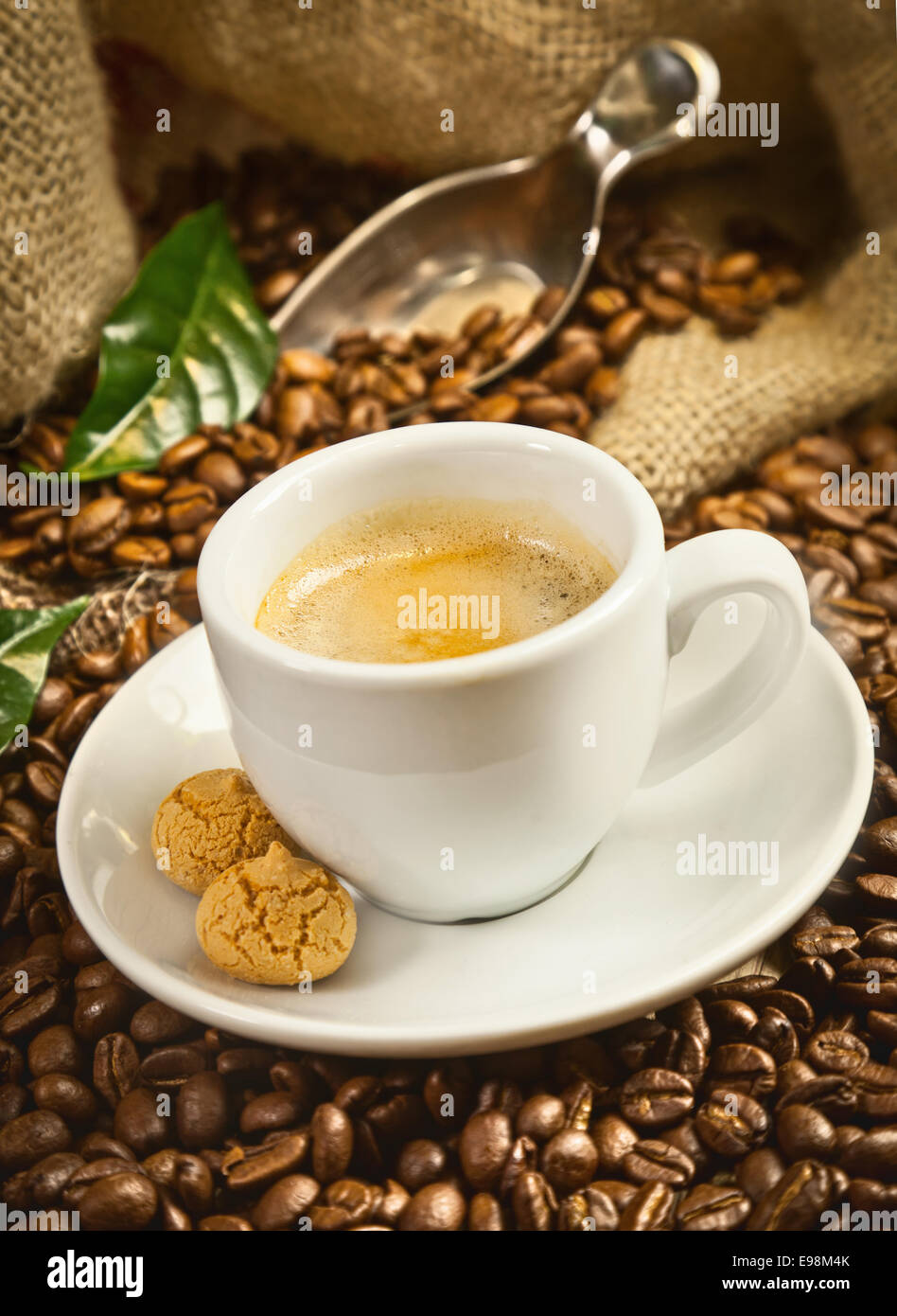 Espressotasse mit frisch gebrühtem Kaffee und Bohnen Stockfoto