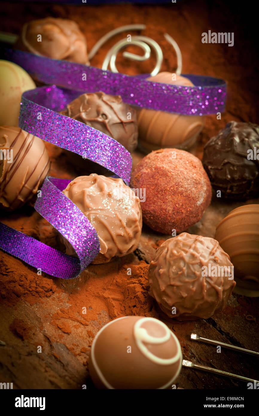 Pralinen mit Vignette und ein lila Band auf einem Kakao gepudert Hintergrund Stockfoto