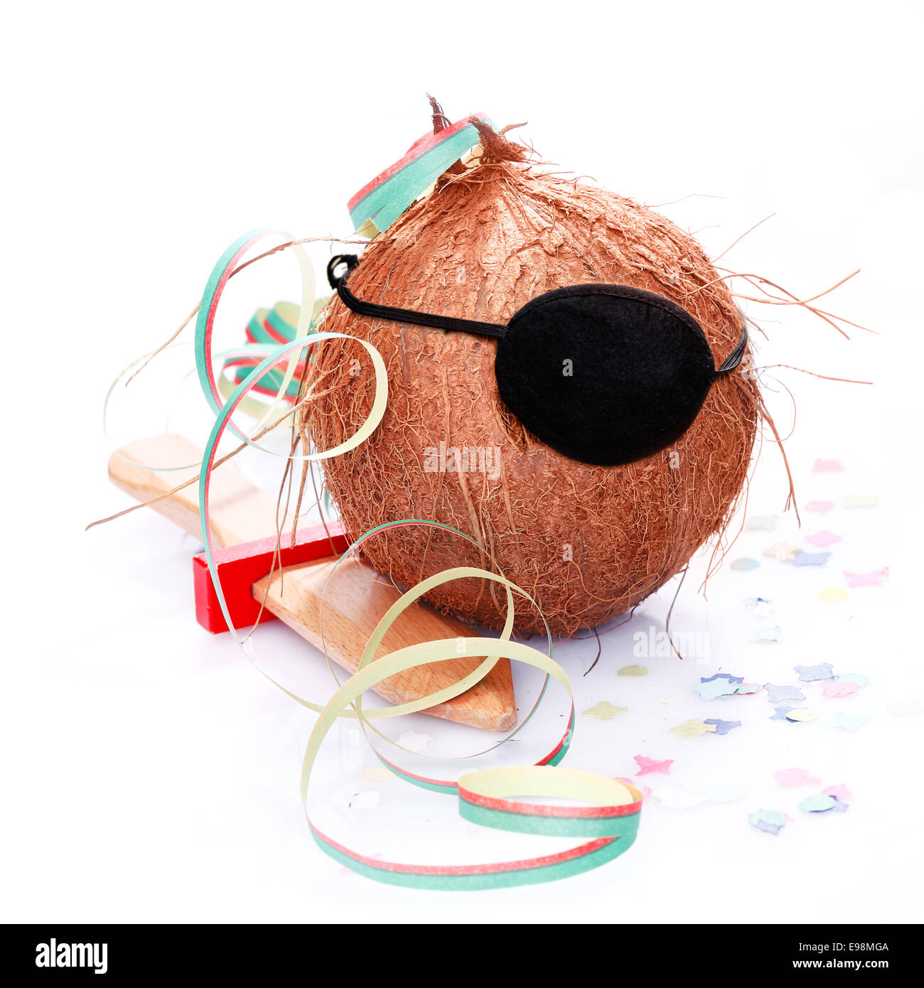 Kokosnuss mit einer Augenklappe, Konfetti und ein Papier-Streamer. Für kleine Piraten und Karibik und tropische Konzepte. Stockfoto