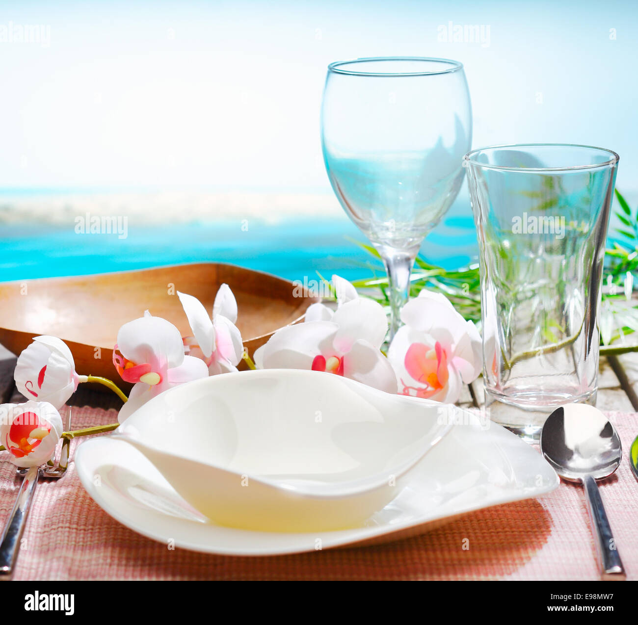 Stilvolle Gedeck mit Orchideen und schöne moderne Geschirr in einem exotischen Restaurant am Strand Stockfoto