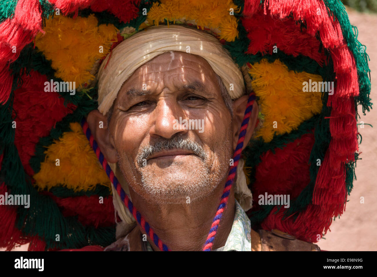 Berber Mann im traditionellen roten Hut und Kleidung am Jemaa el Fna, Marrakesch, Marokko Stockfoto