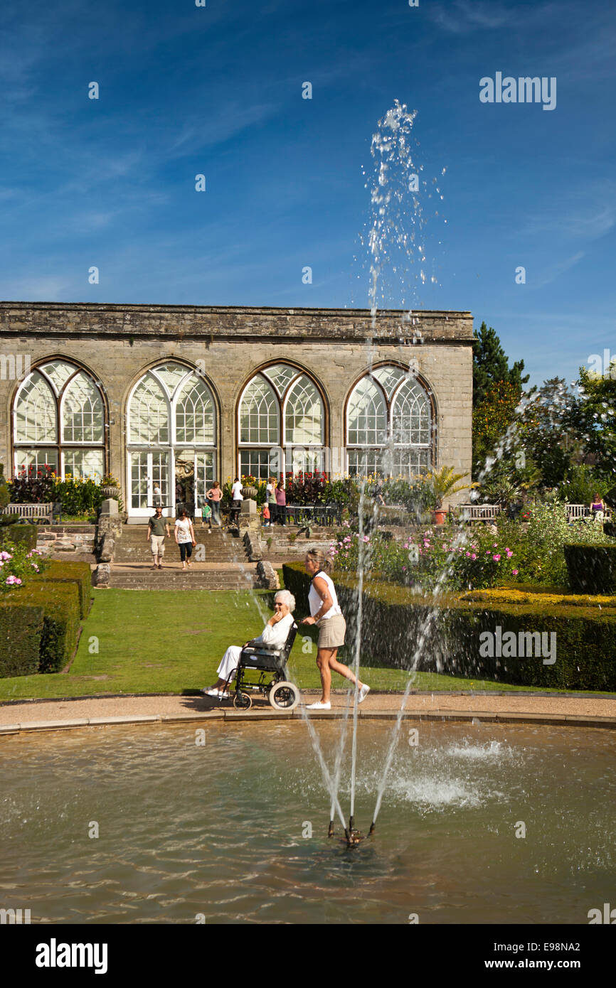 Warwick Castle, Warwickshire, England, UK Gärten, Besucher im Rollstuhl vorbei Orangerie und Brunnen Stockfoto