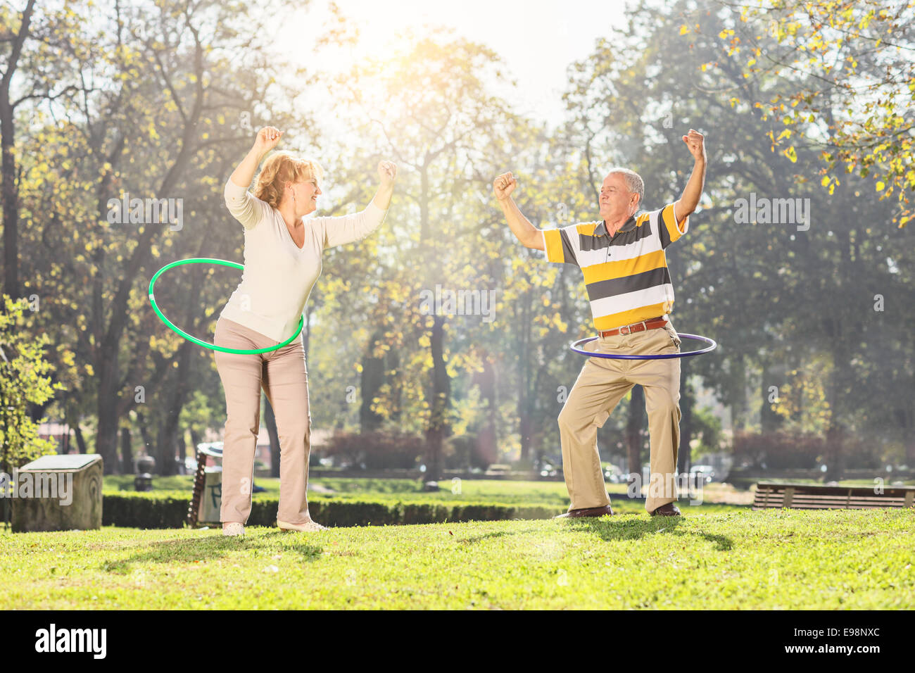 Älteres Paar Training mit Hula Hoops im Park an einem sonnigen Tag Stockfoto