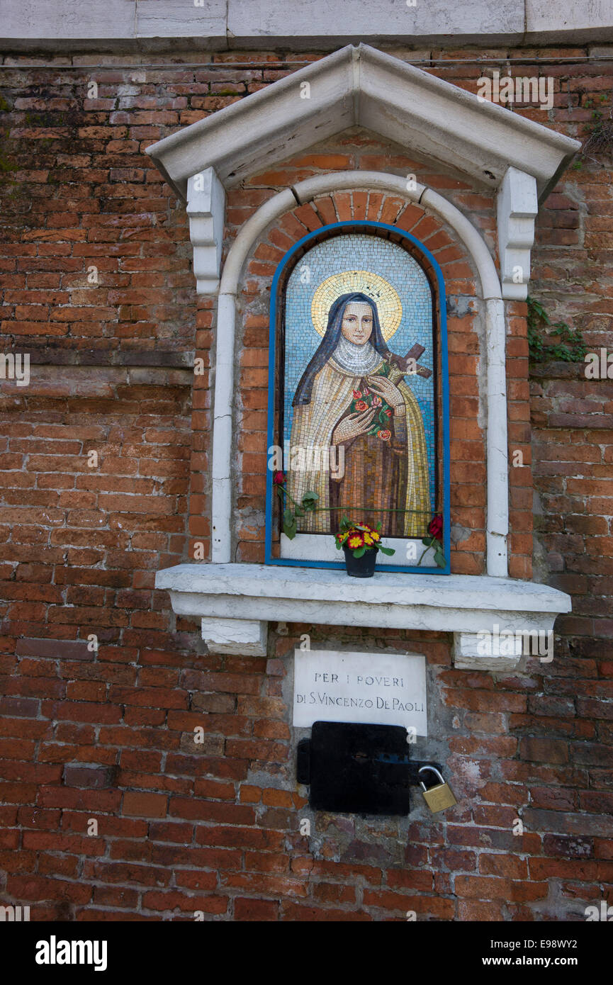 St. Teresa von Avila Symbol inmitten einer Außenwand, Venedig, Italien. Stockfoto