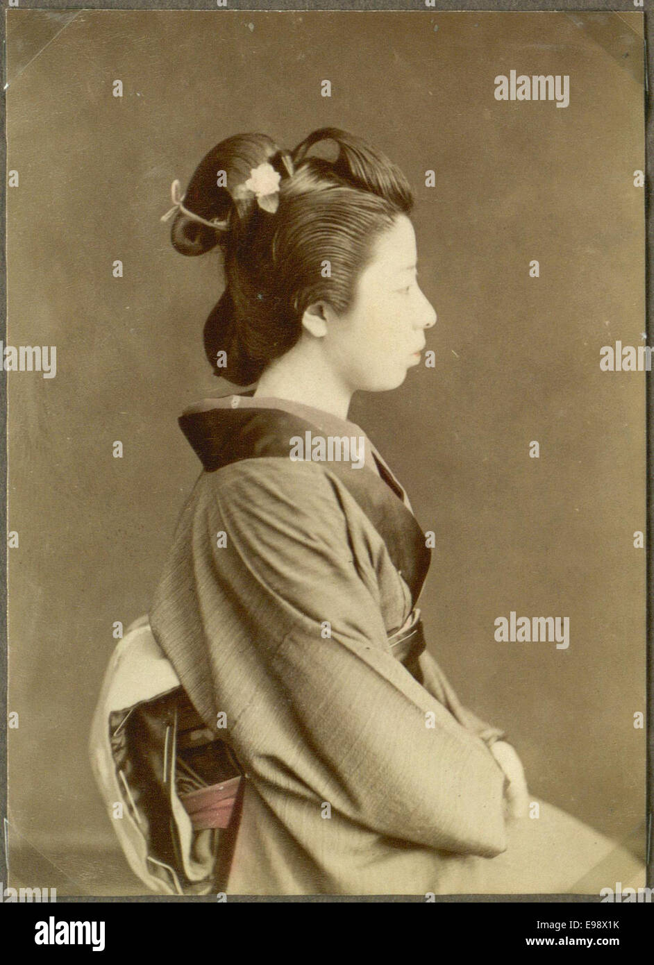 Ein handkoloriertes Vintage-Foto einer japanischen Frau in traditioneller Kleidung. Das Foto wurde von Hand coloriert und zeigt eine historische Szene aus Japan. Stockfoto