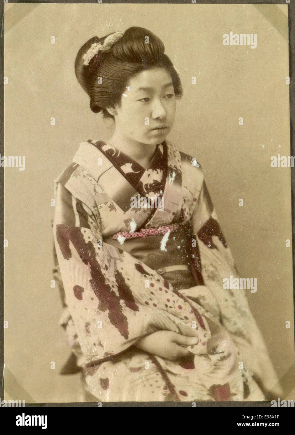 Ein Porträt einer Frau aus Japan mit traditioneller japanischer Kleidung. Das Foto fängt einen bedeutenden kulturellen Moment ein, der den Kleidungsstil und das Verhalten der damaligen Zeit widerspiegelt. Stockfoto