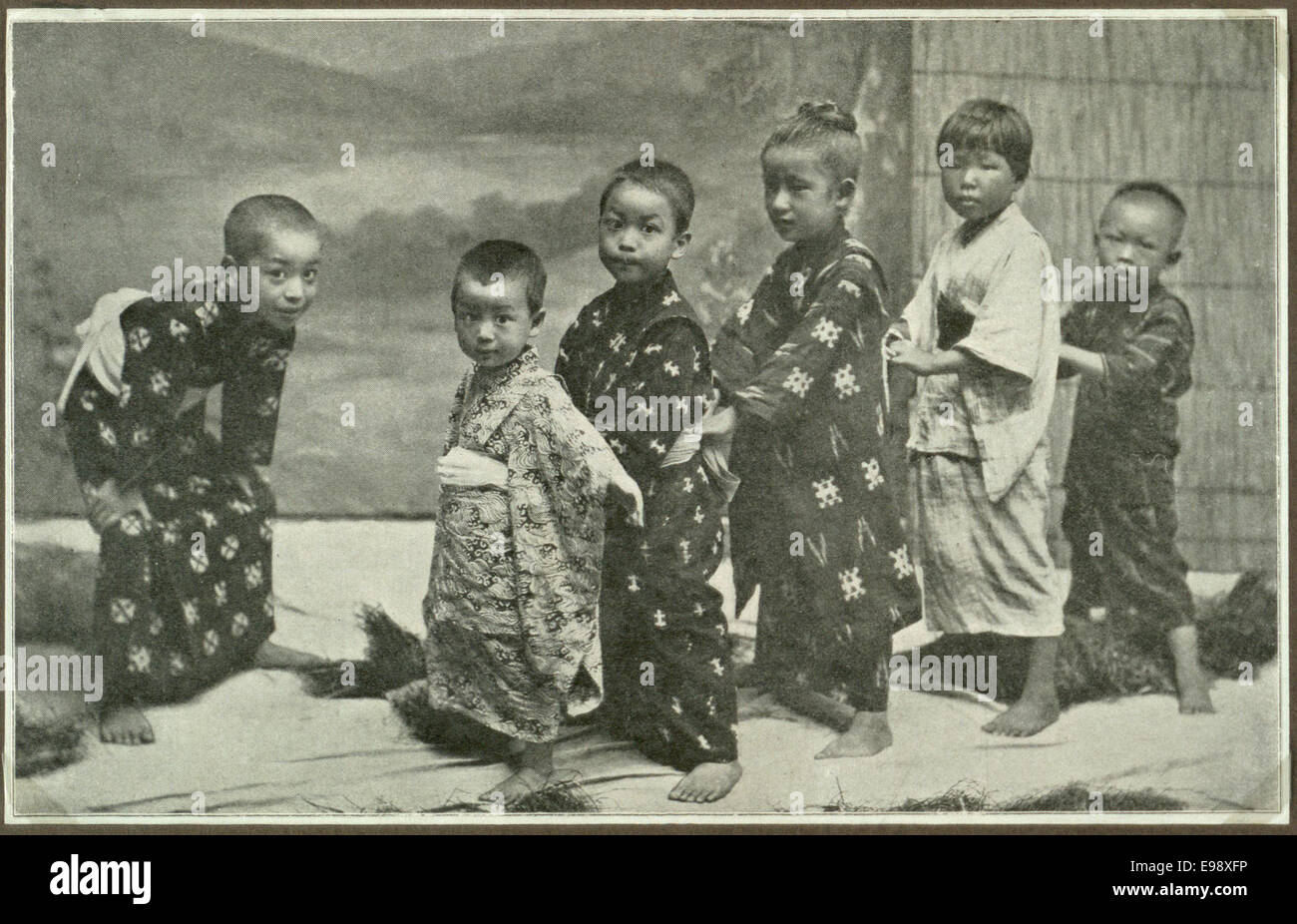 Vintage-Fotografie japanischer Kinder in traditioneller Kleidung, die eine kulturelle Szene aus Japan widerspiegelt. Das Bild fängt die Unschuld und den traditionellen Lebensstil dieser Zeit ein. Stockfoto