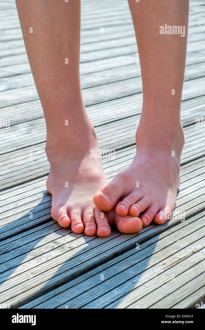 Kindes Beinen barfüßig auf Holzboden Stockfoto