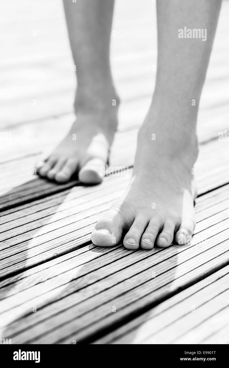 Kindes Beinen barfüßig auf Holzboden Stockfoto