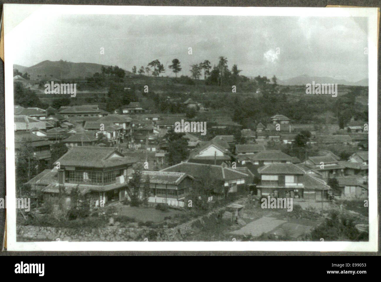 Vintage-Blick auf eine japanische Stadt mit urbaner Landschaft und architektonischen Elementen einer älteren Zeit. Das Foto beleuchtet die traditionellen Aspekte der Stadt und bietet eine historische Perspektive auf Japans Stadtentwicklung. Stockfoto