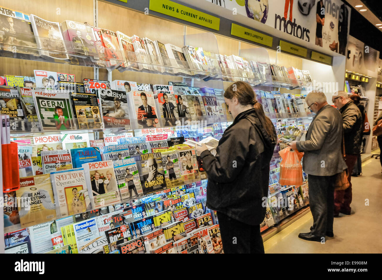 Männer lesen Zeitschriften in einem Geschäft Stockfoto