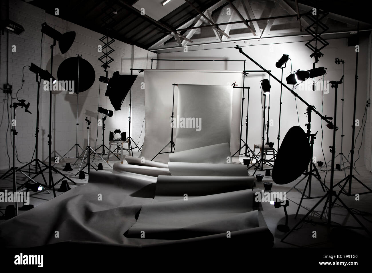 ein Fotostudio mit allen Beleuchtungseinrichtungen und Papier Hintergrund Rollen angelegt, um den Raum zu demonstrieren Stockfoto