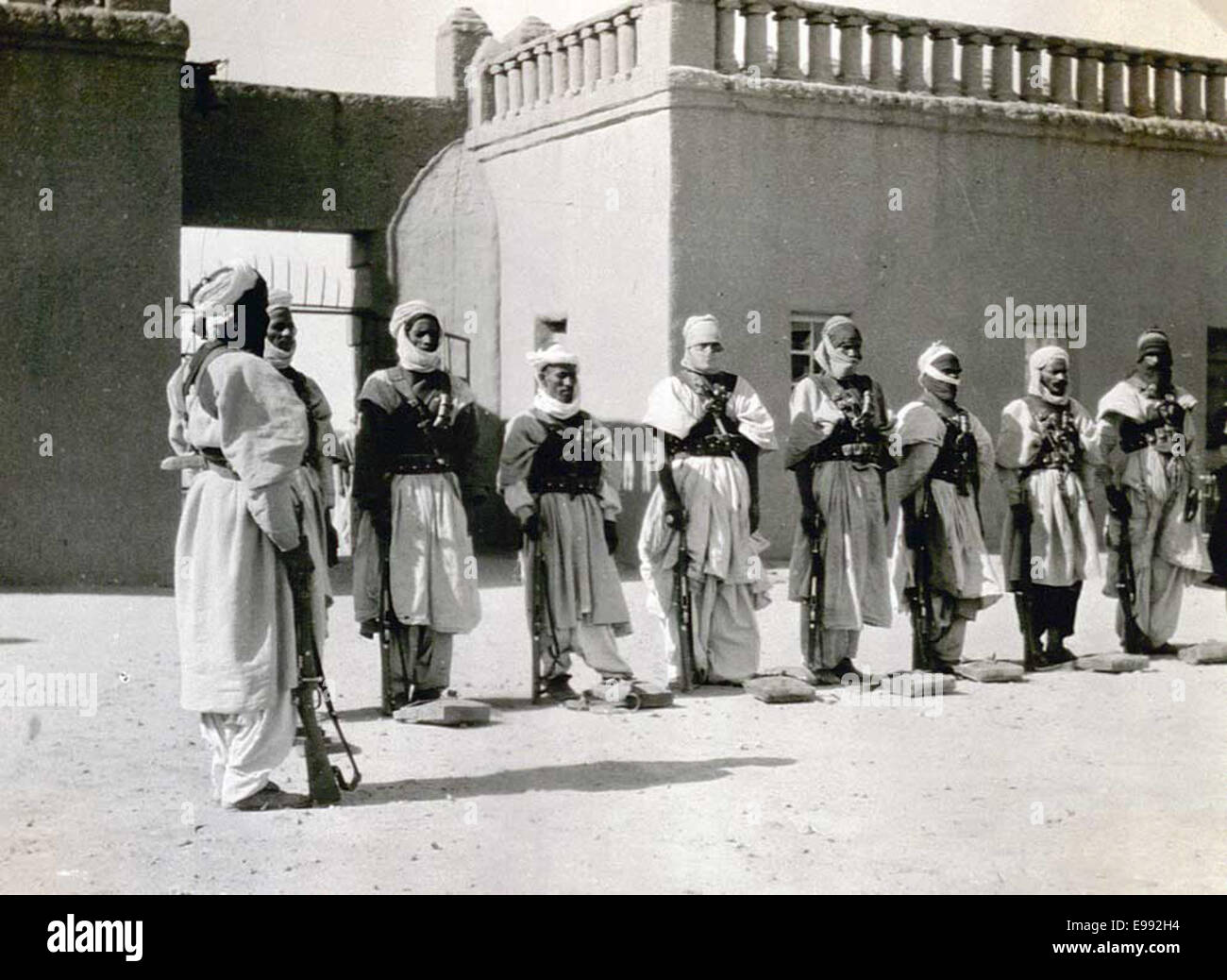 Ein Foto, das arabische Soldaten und ein Tuareg-Individuum in Fort Tamanrasset in der Sahara in Algerien zeigt. Das Bild zeigt die kulturelle Vielfalt und militärische Präsenz in der Gegend während des frühen 20. Jahrhunderts. Stockfoto