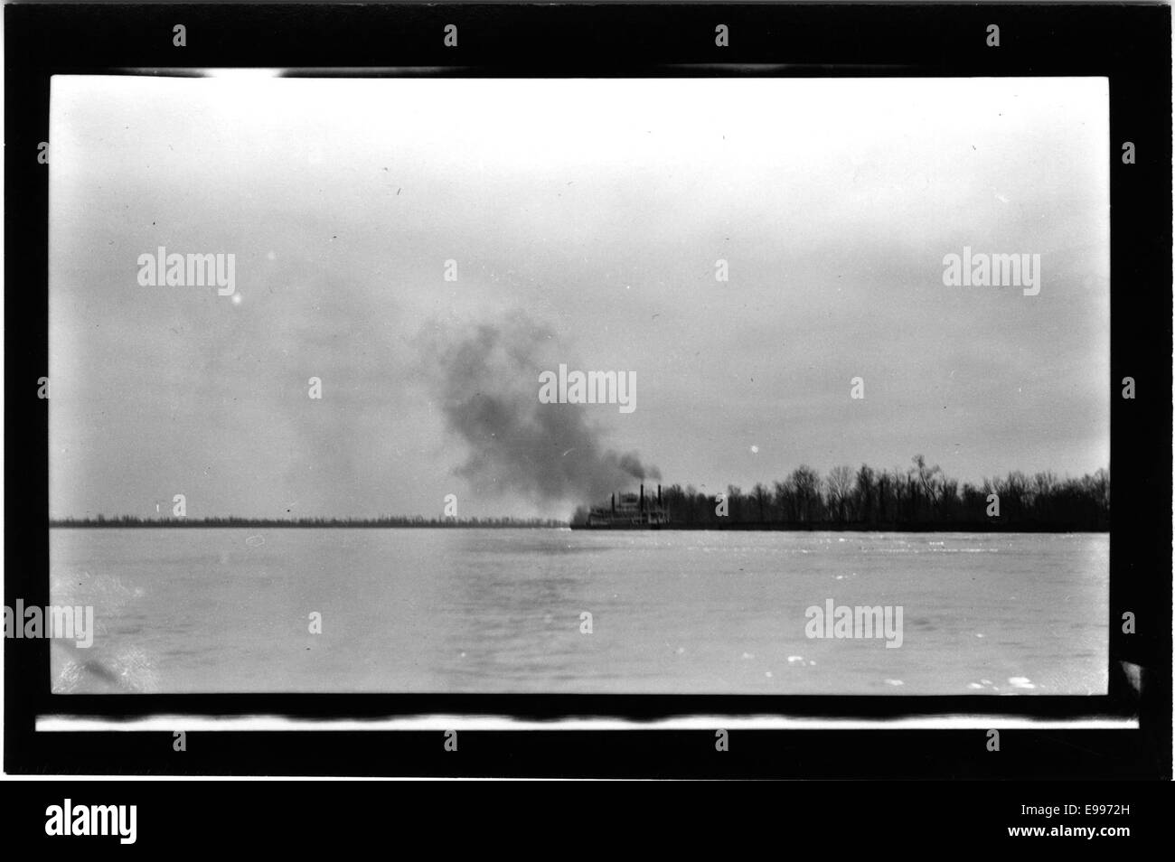 Ein Foto, das ein Boot in der Ferne auf einem Gewässer zeigt, aufgenommen in einem schwachen negativen Stil. Das Bild hebt die Silhouette des Bootes auf dem Wasser hervor. Stockfoto