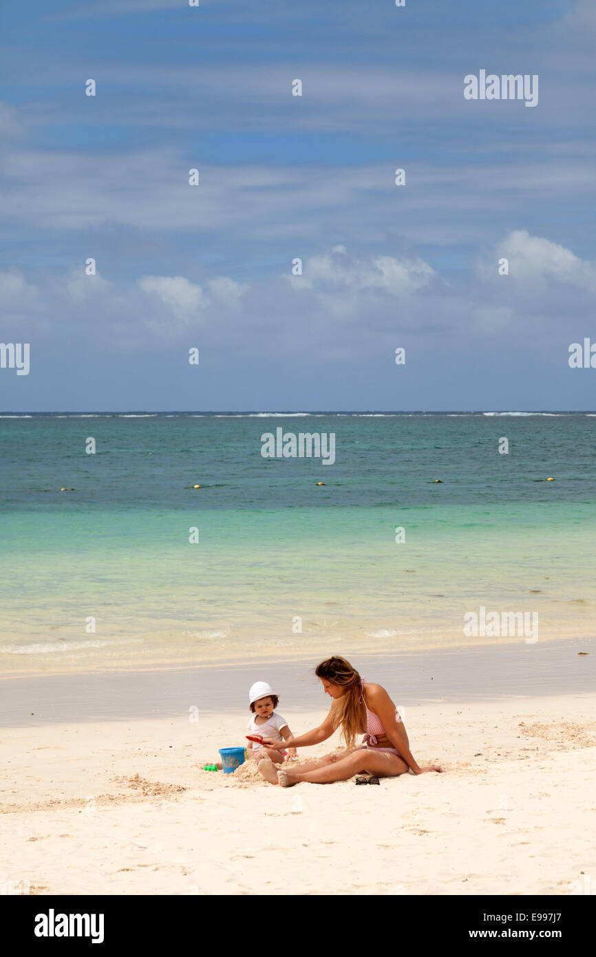 Mutter und Kind spielt auf einem sandigen Strand im Urlaub, Strand von Belle Mare, Mauritius Stockfoto
