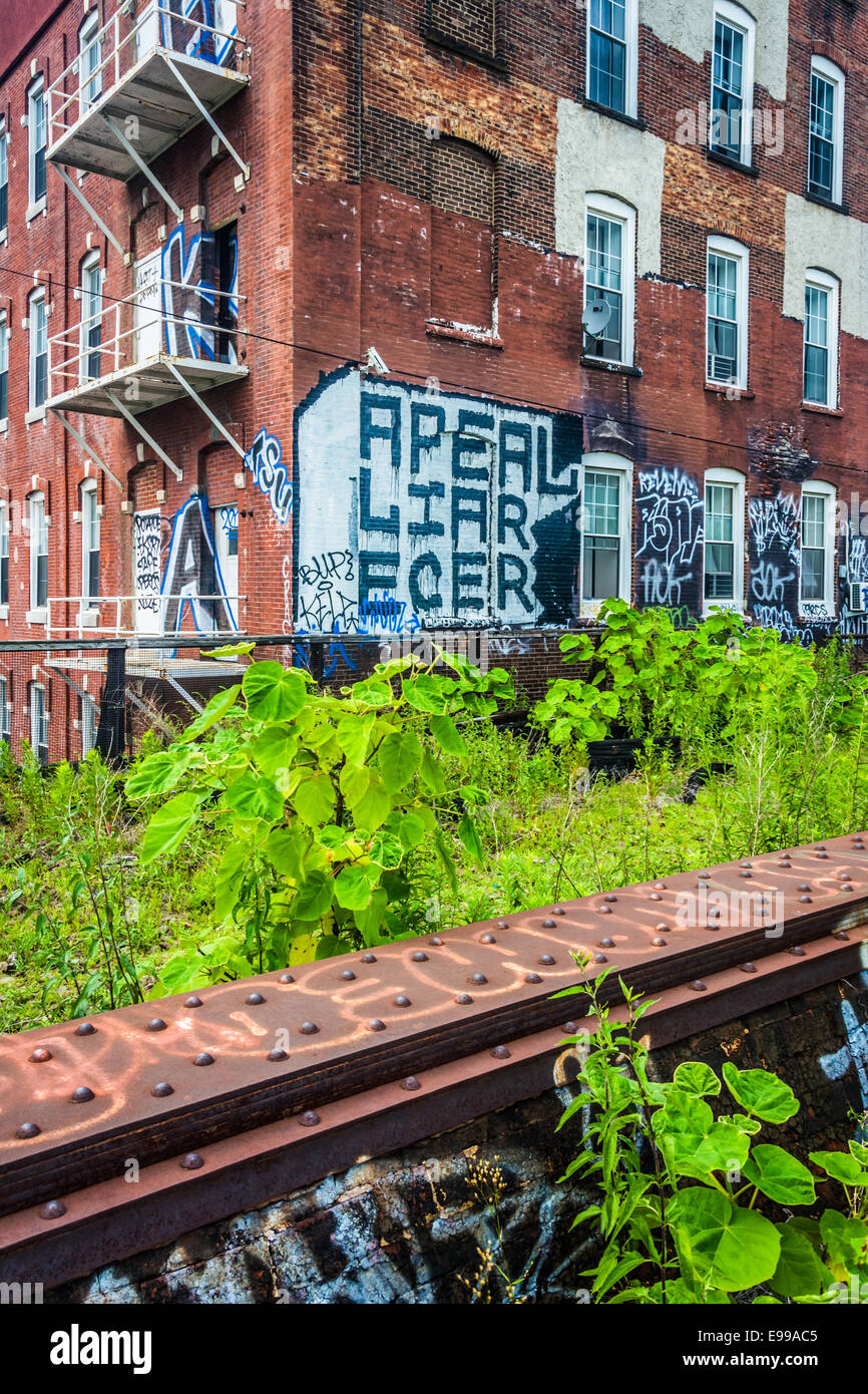 Graffiti auf einem alten Backsteingebäude, gesehen von der Lesung-Viadukt in Philadelphia, Pennsylvania. Stockfoto