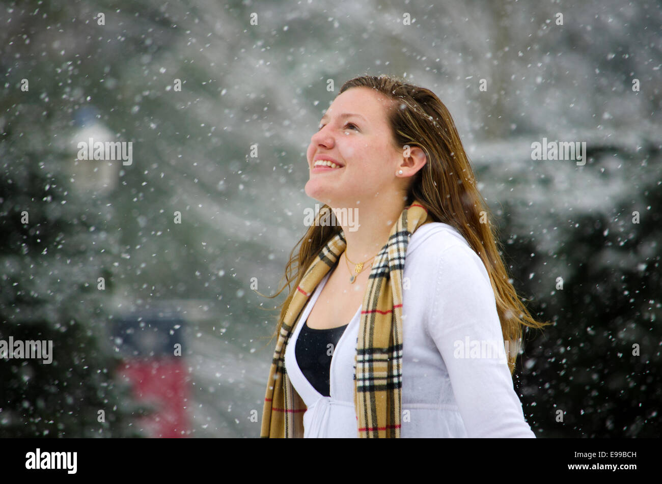 Leise rieselt der Schnee: eine junge Frau ihren Kopf erhebt gegen eine schöne Schnee-Dusche. Stockfoto