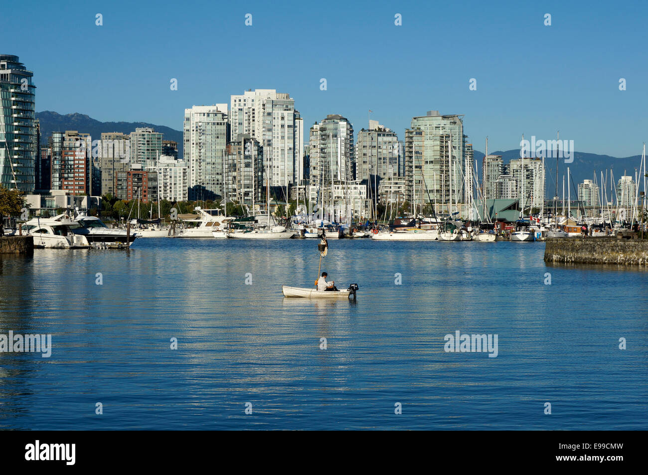 Mann sitzt allein in einem kleinen Segelboot, False Creek, Vancouver, Britisch-Kolumbien, Kanada Stockfoto